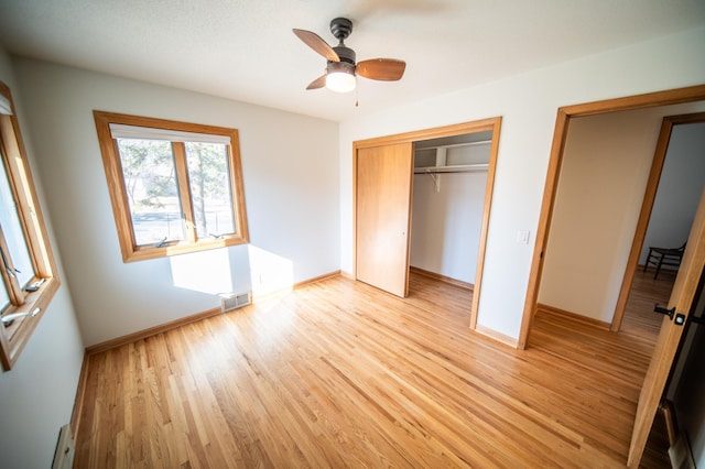 unfurnished bedroom featuring light wood finished floors, visible vents, baseboards, and a closet