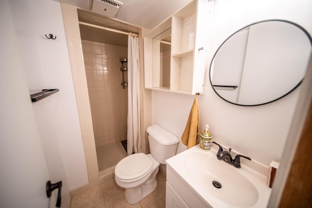 bathroom with tile patterned flooring, toilet, vanity, and a tile shower