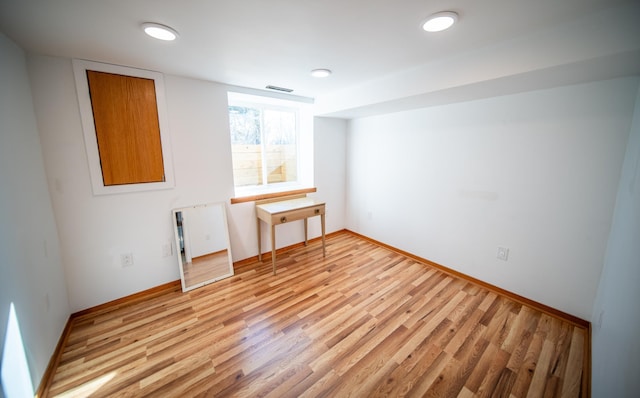 empty room featuring baseboards, visible vents, and light wood finished floors