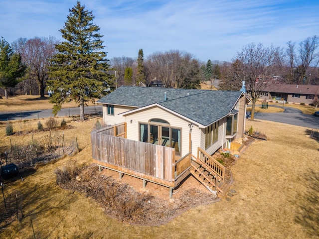 rear view of property with a shingled roof and a deck