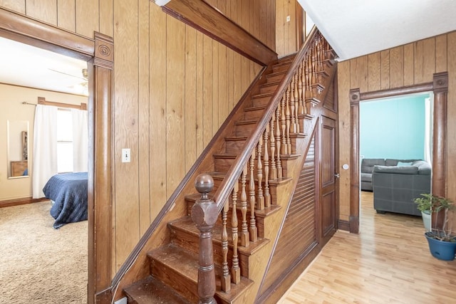 stairway featuring hardwood / wood-style floors and wooden walls