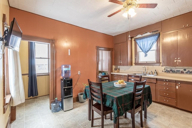 tiled dining area with ceiling fan, plenty of natural light, and sink