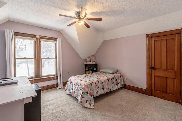 carpeted bedroom featuring a textured ceiling, vaulted ceiling, and ceiling fan