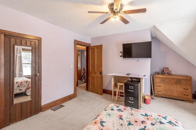 carpeted bedroom featuring a textured ceiling, ceiling fan, and lofted ceiling