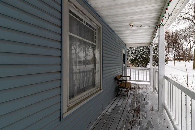 snow covered deck with a porch