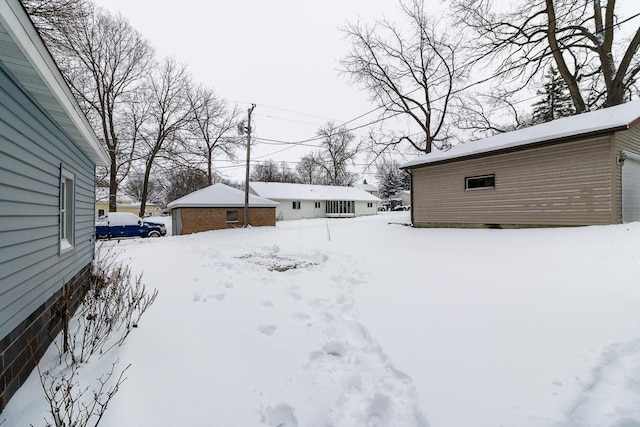 yard covered in snow with an outbuilding and a garage