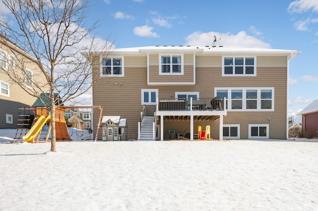 snow covered rear of property featuring a playground