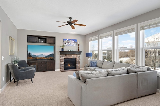 living room with ceiling fan, light colored carpet, a fireplace, and a wealth of natural light