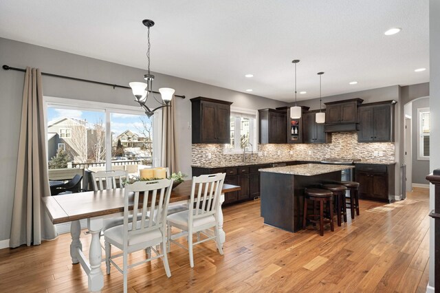 dining room featuring sink, light hardwood / wood-style flooring, and a notable chandelier