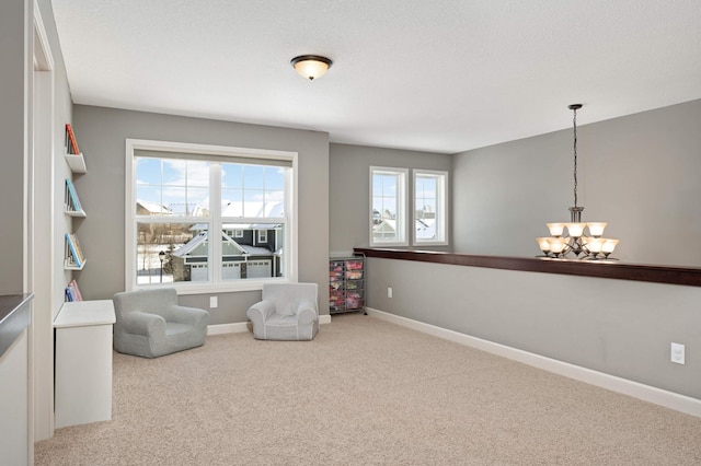 sitting room featuring carpet flooring, a textured ceiling, and an inviting chandelier