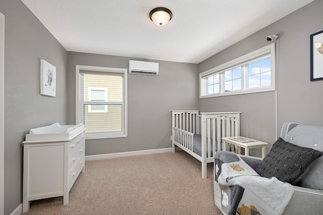 bedroom with light carpet, a wall unit AC, and a textured ceiling