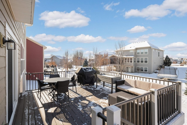 snow covered deck with area for grilling and a trampoline