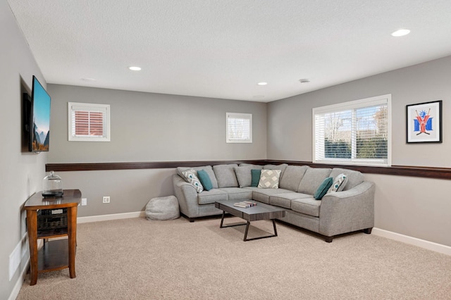 carpeted living room featuring baseboards, a textured ceiling, and recessed lighting