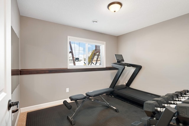 workout room featuring baseboards and a textured ceiling