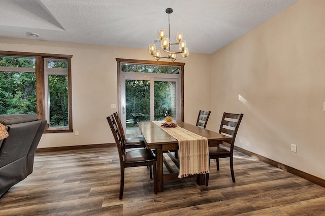 dining area with a textured ceiling, dark hardwood / wood-style flooring, plenty of natural light, and a notable chandelier