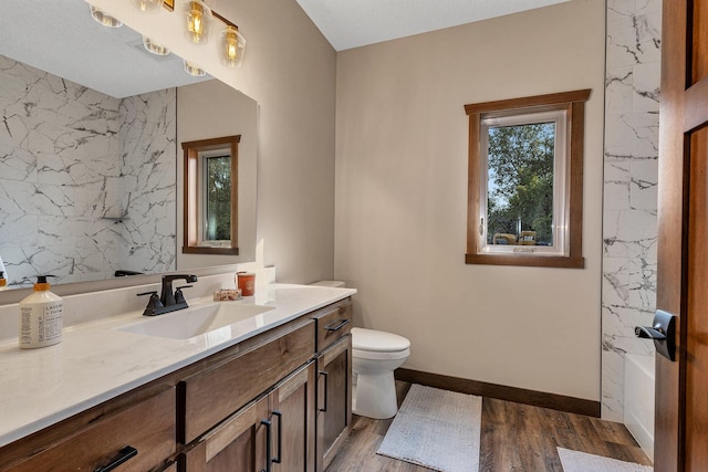 bathroom featuring hardwood / wood-style flooring, vanity, toilet, and a textured ceiling