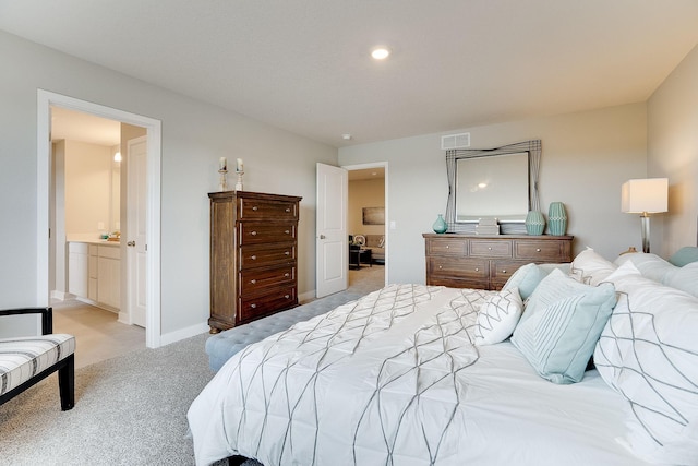 bedroom featuring light colored carpet and ensuite bath