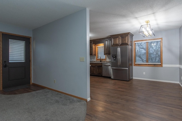 kitchen featuring a textured ceiling, sink, stainless steel appliances, and dark hardwood / wood-style floors