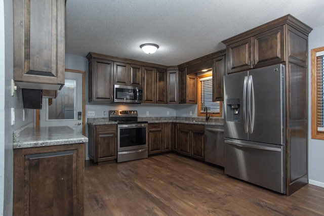 kitchen with dark brown cabinets, dark hardwood / wood-style floors, and stainless steel appliances