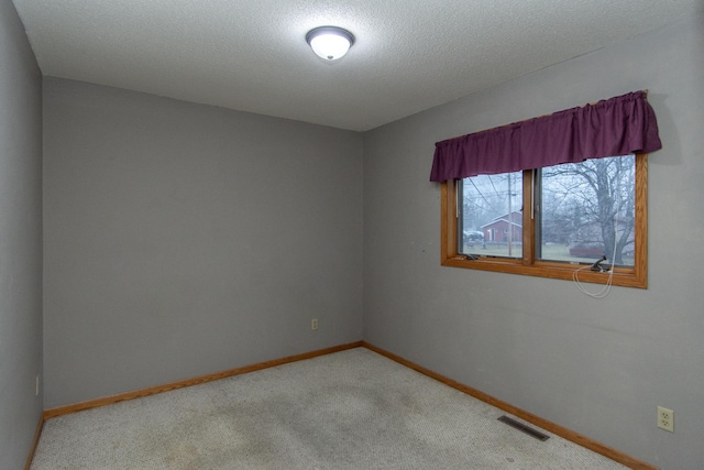 empty room featuring carpet flooring and a textured ceiling