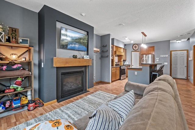 living room with a textured ceiling and light wood-type flooring