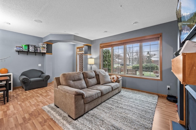 living room with a textured ceiling and light hardwood / wood-style flooring