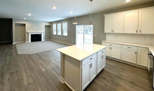 kitchen with hanging light fixtures, white cabinetry, a kitchen island, and backsplash