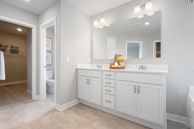 bathroom with vanity, a chandelier, and toilet