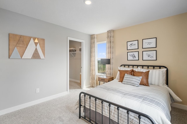 carpeted bedroom featuring a walk in closet and a closet