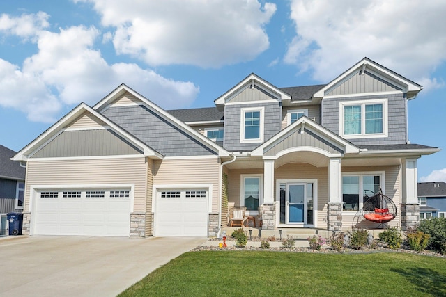 craftsman-style house with a garage, covered porch, and a front yard