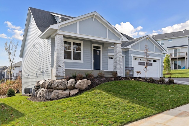 view of front of house with a garage, a front lawn, and central air condition unit