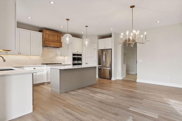 kitchen with pendant lighting, a center island, white cabinetry, and stainless steel appliances