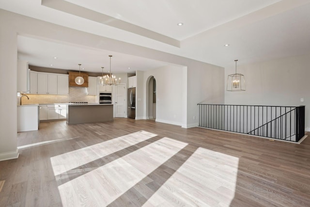 unfurnished living room with light hardwood / wood-style floors and sink