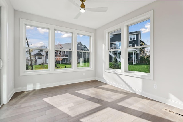 unfurnished sunroom featuring ceiling fan