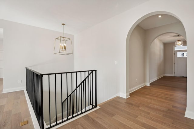 hall featuring an inviting chandelier and light wood-type flooring