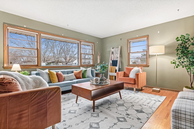 living room with a healthy amount of sunlight, a textured ceiling, and light hardwood / wood-style floors