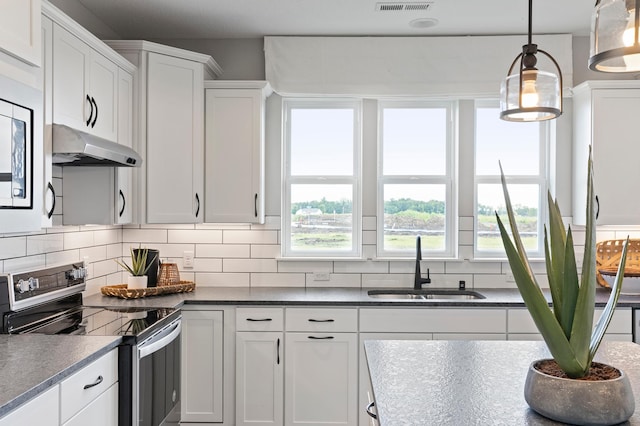 kitchen featuring decorative backsplash, sink, electric stove, decorative light fixtures, and white cabinets