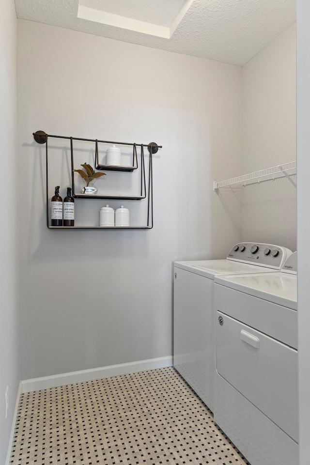 laundry area with a textured ceiling and separate washer and dryer