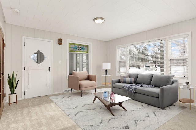 living area with baseboards and light colored carpet