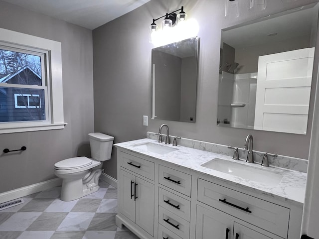 bathroom with vanity, toilet, and a shower