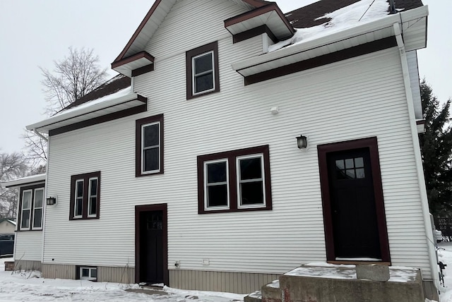 view of snow covered rear of property