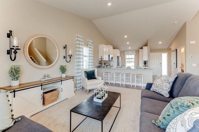 carpeted living room with lofted ceiling