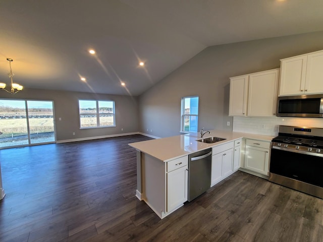 kitchen featuring kitchen peninsula, hanging light fixtures, dark hardwood / wood-style floors, appliances with stainless steel finishes, and white cabinetry