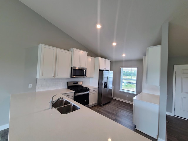 kitchen featuring appliances with stainless steel finishes, tasteful backsplash, sink, dark hardwood / wood-style floors, and white cabinetry