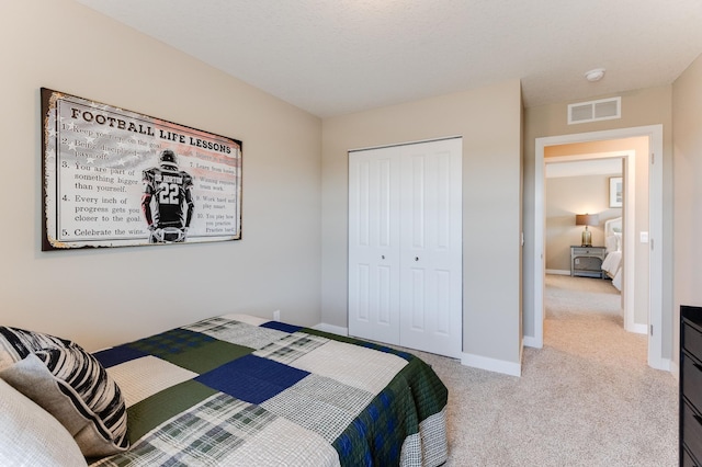 carpeted bedroom featuring a closet and a textured ceiling