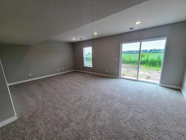 carpeted spare room with a textured ceiling