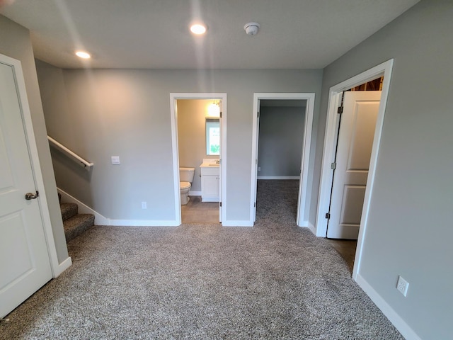 unfurnished bedroom featuring carpet flooring, connected bathroom, and a closet