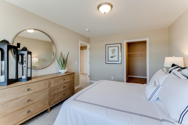 carpeted bedroom featuring a spacious closet and a closet