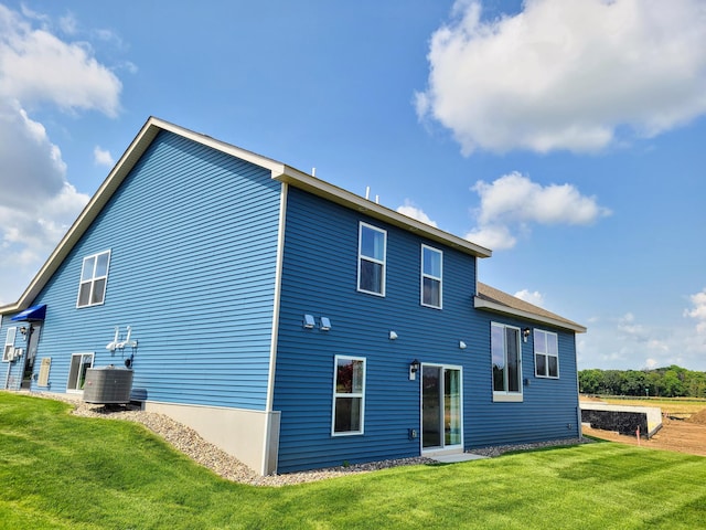 rear view of property with a yard and central AC unit