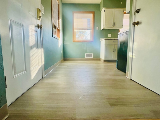 corridor with light hardwood / wood-style floors